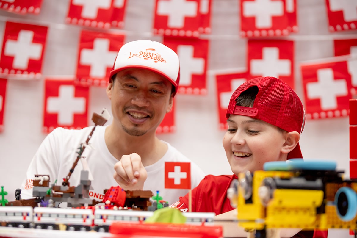 A FIRST LEGO League student building their robot at FIRST Championship with the help of a mentor.