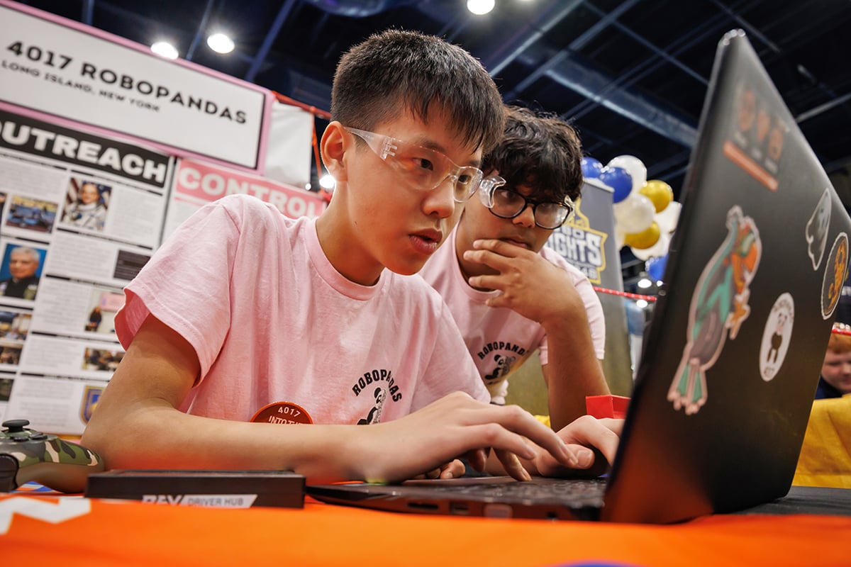 Two FIRST Tech Challenge students programming robot at FIRST Championship.